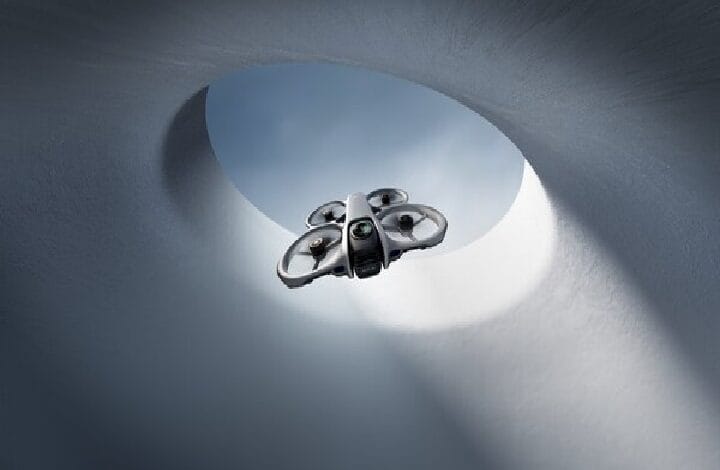 Quadcopter drone flying inside a circular concrete shaft toward the daylight opening.