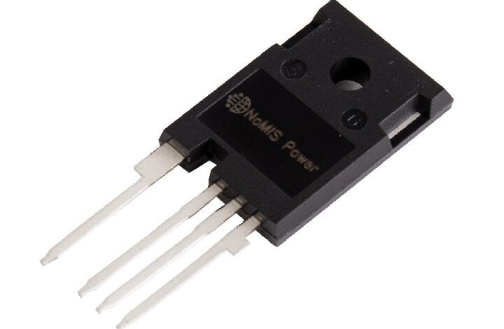 Close-up of a black NOMIS Power 4-pin connector module with four flat pins extending from the bottom and a circular mounting hole on top edge.