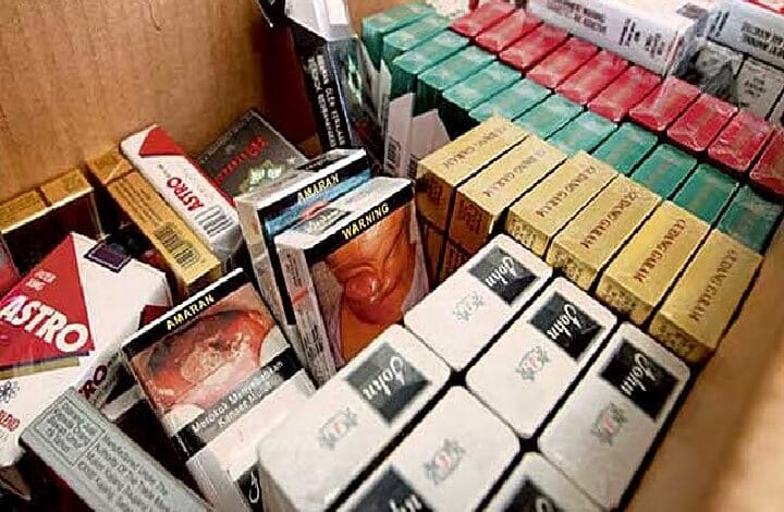 A mix of small boxed products in a cardboard bin, with colorful yellow, green, red, and white packaging stacked together.