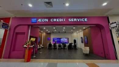 aeon superbike - Wilayah.com.my Pink storefront of AEON Credit Service in a mall, with a curved archway and a flower arrangement to the left; service counters visible inside.