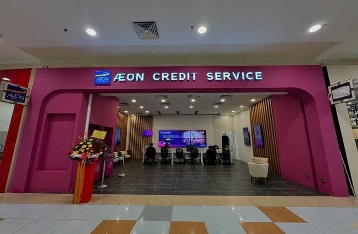 aeon superbike - Wilayah.com.my Pink storefront of AEON Credit Service in a mall, with a curved archway and a flower arrangement to the left; service counters visible inside.