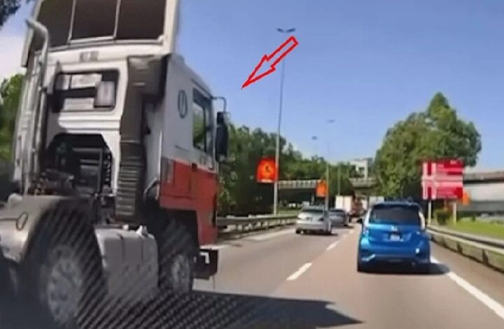 air borneo - Copy - Copy - Wilayah.com.my Large construction truck in the left lane of a multi-lane highway, with a blue car in the right lane; a small bird flies in the blue sky above.
