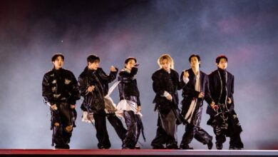 bts - Wilayah.com.my Seven male dancers in dark outfits performing a choreographed routine on a smoky stage with red lighting on the floor.