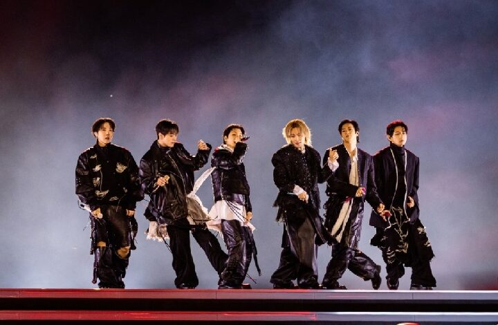 bts - Wilayah.com.my Seven male dancers in dark outfits performing a choreographed routine on a smoky stage with red lighting on the floor.