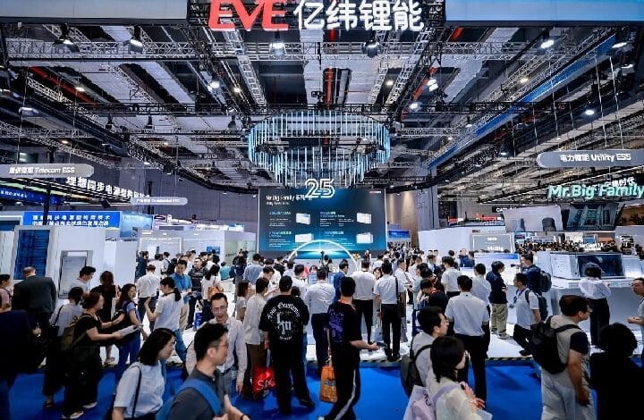 eve snec - Wilayah.com.my Busy technology expo hall with many booths and attendees, a circular chandelier overhead, and a large 'EVE' sign in red at the top center.