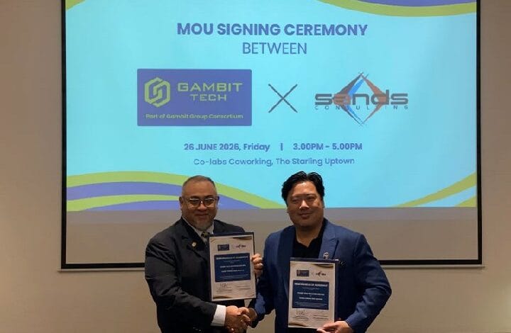 Two men in suits shake hands while holding framed certificates at an MOU signing ceremony; a slide behind displays the event title and partner logos.