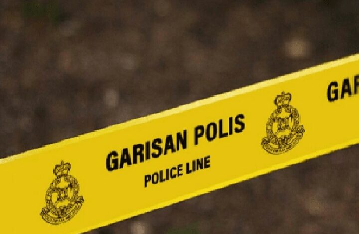 Yellow police line tape marked GARISAN POLIS (POLICE LINE) stretches across the scene with police emblems visible on the sides, a crime-scene barrier.