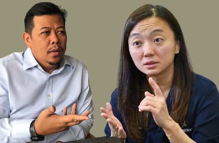 hannah 2 - Wilayah.com.my Two adults seated and talking; man on the left gestures with an open hand while the woman on the right speaks, using finger gestures to emphasize a point.