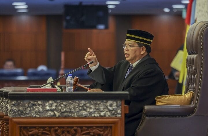 johari abdul - Wilayah.com.my Judge in a black robe and striped cap speaks from a judge's bench, gesturing with a raised finger beside a gavel and microphone.