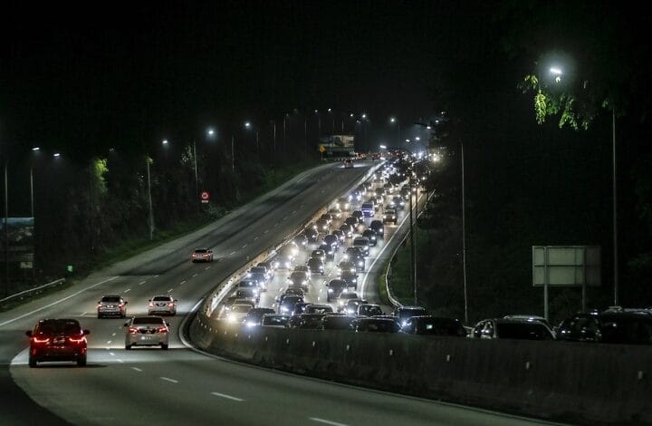 kl led light road 2 - Wilayah.com.my Nighttime highway with heavy traffic and bright headlights on both directions, streetlights lining the road.