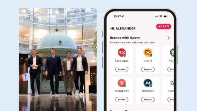 loyalty juggernaut 2 - Wilayah.com.my Four executives walk through a glass atrium beside a phone showing a Spenn app dashboard.