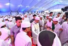 majlis tahfiz - Wilayah.com.my Large crowd of men in white traditional dress under a blue-lit tent; a cameraman records on the right.