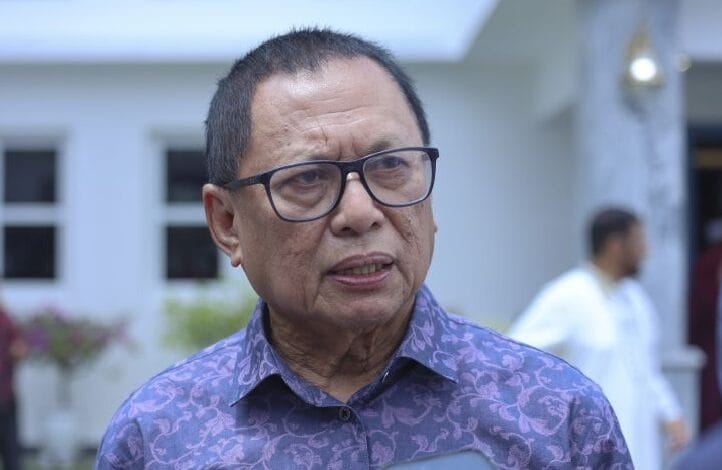 mohd puad zarkashi - Wilayah.com.my A middle-aged man wearing glasses and a purple patterned shirt speaks outdoors near a white building.