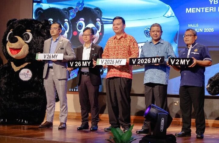 no plate 2 - Wilayah.com.my Six men on a stage holding novelty license plates, with a bear mascot on the left and a blue car backdrop.