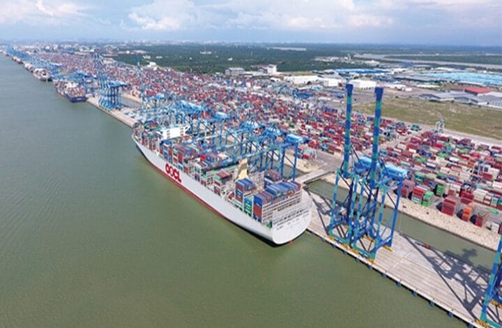 pelabuhan klang - Wilayah.com.my A container ship docked at a busy port with blue gantry cranes loading colorful containers onto the cargo ship.