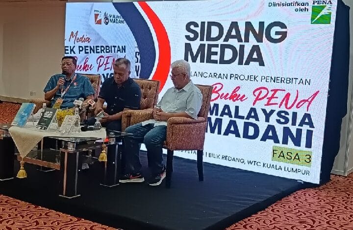 Panel of three men on stage during a media briefing, large banner reads SIDANG MEDIA and MALAYSIA MADANI behind them