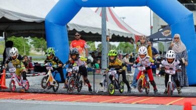 pushbike lion rocket - Wilayah.com.my Young children on small bikes race at a start line under a blue Decathlon arch, with spectators watching nearby.
