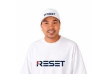 reset - Wilayah.com.my Man wearing a white cap and T-shirt with the blue 'RESET' logo, smiling.