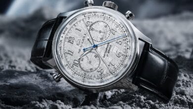seagull watch - Wilayah.com.my Luxury chronograph wristwatch with a silver dial, three subdials and blue hands on a black leather strap resting on rocky terrain.