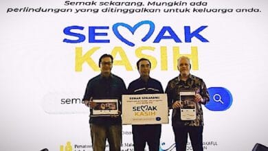 Three men stand in front of a white banner, holding tablets; the banner reads SEMAK KASIH and Indonesian slogans.