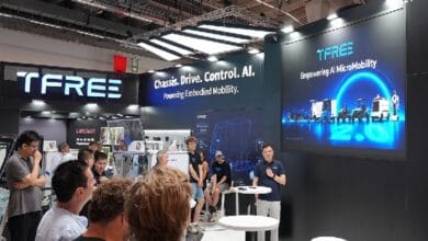 TFREE trade show booth with a speaker and audience, displaying the tagline ‘Chassis. Drive. Control. AI. Powering Embodied Mobility.’