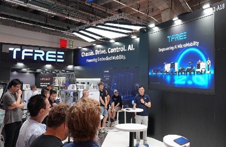 TFREE trade show booth with a speaker and audience, displaying the tagline ‘Chassis. Drive. Control. AI. Powering Embodied Mobility.’