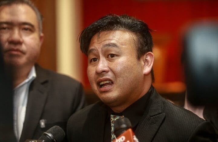 wong tuck meng - Wilayah.com.my Asian man in suit speaking to reporters, microphones in foreground at a press event