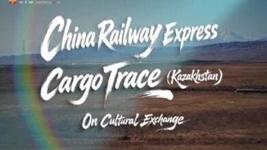 Poster banner for China Railway Express Cargo Trace (Kazakhstan) on Cultural Exchange, set against a desert landscape with a rainbow arc in the foreground.
