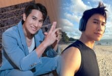 daniel fong 2 - Wilayah.com.my Two men on a sunny beach pose for a photo: one in a blue suit smiling and making a hand gesture, the other wearing a black sleeveless shirt with headphones, by the sea.