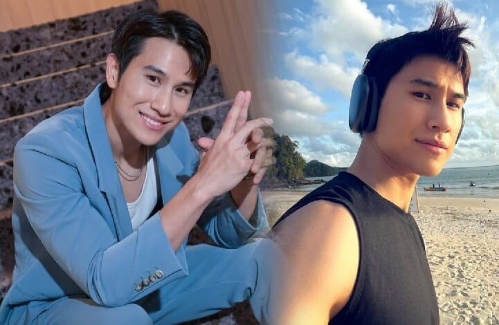daniel fong 2 - Wilayah.com.my Two men on a sunny beach pose for a photo: one in a blue suit smiling and making a hand gesture, the other wearing a black sleeveless shirt with headphones, by the sea.