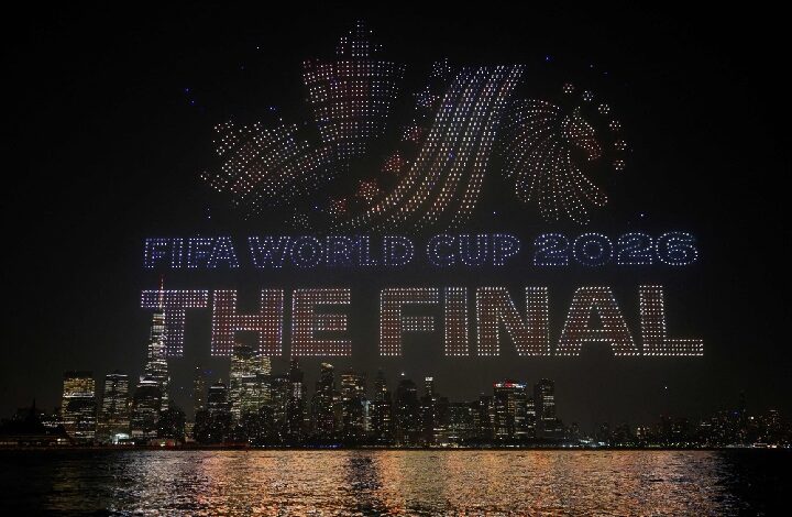 dataran merdeka - Wilayah.com.my Nighttime city skyline with a drone light show spelling 'FIFA World Cup 2026 THE FINAL' over the water.