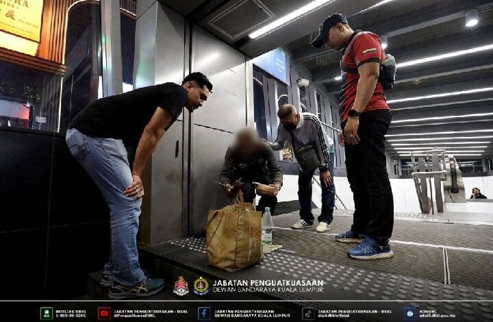 Enforcement officers inspect a man's bag at a security checkpoint near a baggage scanner in a transit station, with bystanders nearby.