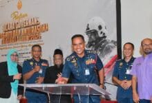 el nino - Wilayah.com.my Group of uniformed officers and civilians at a signing ceremony, with a podium and a backdrop banner in Indonesian highlighting security topics.