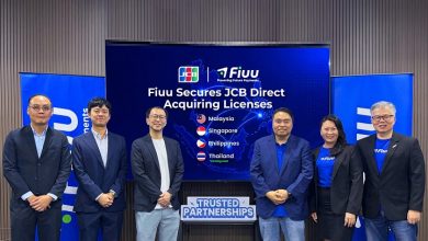 Six professionals in business attire pose in front of a screen announcing Fiiu secures JCB Direct Acquiring Licenses, with country flags listed (Malaysia, Singapore, Philippines, Thailand).