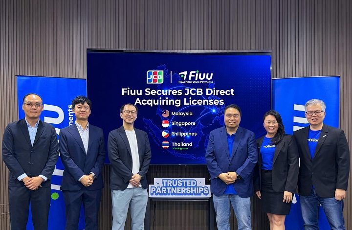 fiuu 2 - Wilayah.com.my Six professionals in business attire pose in front of a screen announcing Fiiu secures JCB Direct Acquiring Licenses, with country flags listed (Malaysia, Singapore, Philippines, Thailand).