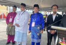 jalaluddin alias - Wilayah.com.my Four men in traditional Malay baju melayu and a man in a suit stand under a white tent at an outdoor ceremony.