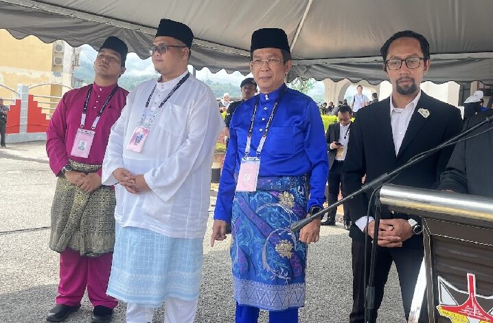 jalaluddin alias - Wilayah.com.my Four men in traditional Malay baju melayu and a man in a suit stand under a white tent at an outdoor ceremony.