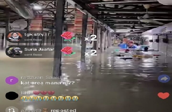 medan selera shah alam - Wilayah.com.my Livestream screenshot of a flooded warehouse with water on the floor, people in the background, and chat comments on the left with emoji reactions on the right.