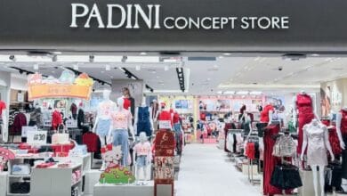 padini - Wilayah.com.my Storefront sign: PADINI CONCEPT STORE and view into a brightly lit apparel shop with mannequins and clothing displays inside.