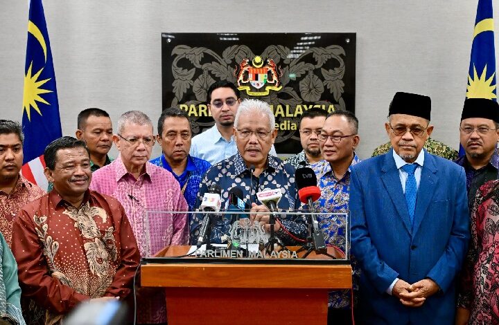pembangkang 2 - Wilayah.com.my Group of Malaysian officials at a press conference behind a podium with multiple microphones, Parliament of Malaysia signage in the background and Malaysian flags on both sides.