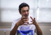 qi razali 2 - Wilayah.com.my Man wearing a Nirvana t-shirt gesturing with his hands while speaking in a bright room