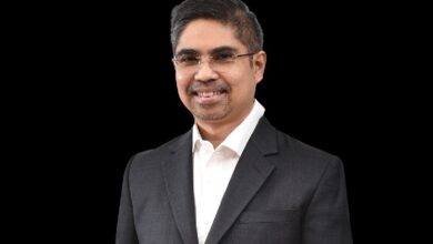 samad majid - Wilayah.com.my Professional man in a dark suit and white shirt, smiling at the camera against a black background.