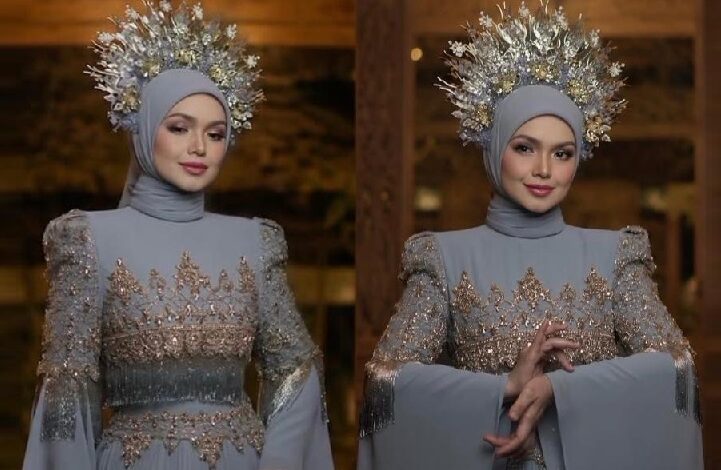 Woman in a light blue gown with gold embroidery and a silver halo headpiece, posing gracefully.", "Two side-by-side portraits of a woman in an ornate hijab dress with beaded sleeves and a metallic halo.", "Elegant blue gown with sparkling embellishments and a crown-like silver halo worn by a hijab-clad model.", "Portraits of a woman in a richly decorated blue dress with tassels and a radiant silver halo.", "Hijab-clad model wearing a beaded blue gown with a jeweled crown-like headpiece, posing confidently."]} }aissez?{