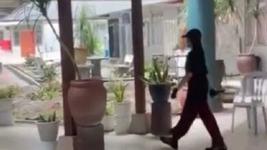 suspek tikam - Wilayah.com.my Person walking through a covered outdoor walkway lined with potted plants and tables.