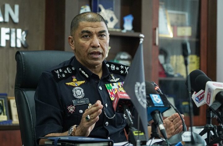yusof hashim - Wilayah.com.my High-ranking police officer in uniform speaks at a press conference, gesturing with hands, with microphones in front and awards/display case in the background.